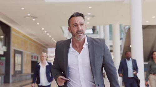 Mature Businessman in a Rush Running and Holding His Passport in Airport