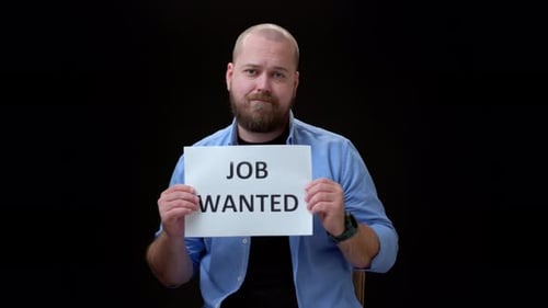 Guy in Blue Shirt on Black Background Hold Piece of Paper with Inscription JOB WANTED Bald Man with