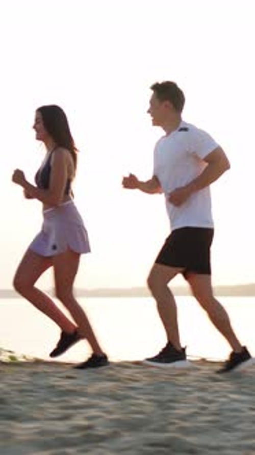 Couple Jogging on Beach at Sunrise