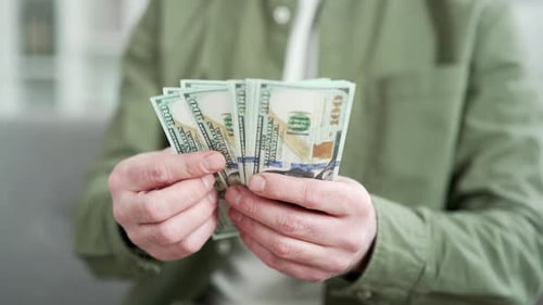 Close up. Male hands count one hundred dollar US bills. Businessman in shirt counting banknotes