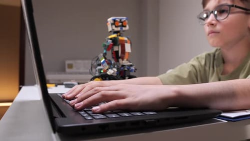 Junge lernt Stem-Konzepte und Robotik-Programmsteuerung für seinen farbenfrohen Lernroboter