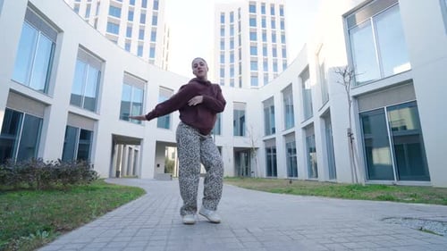 Young Woman Dancing in Front of Buildings
