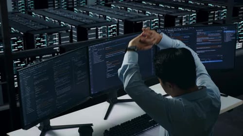 Side View Of Tired Asian Man Developer Stretching While Write Code In Data Center