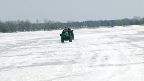 Riding ATVs Across Snowy Rural Winter Landscape