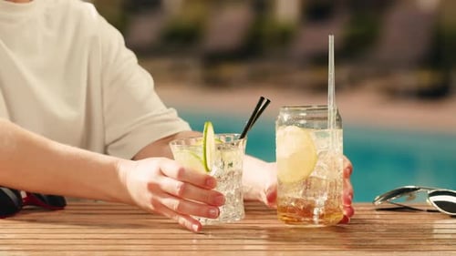 Fruchtcocktail in der Hotelbar Zwei Cocktailgläser Jubel in den Händen auf Meereshintergrund Bartenter