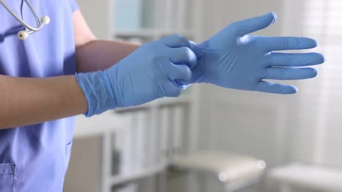 Travailleur médical mettant des gants à l'hôpital, gros plan