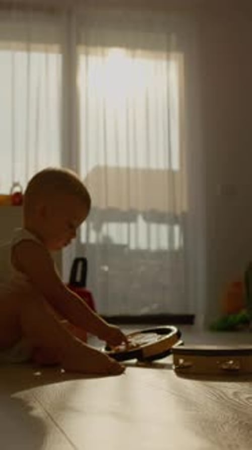 Baby Plays with Toys on Floor at Home