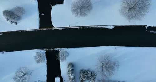 Top down aerial of street road and landscaping in winter snow neighborhood. Drone truck shot to circ