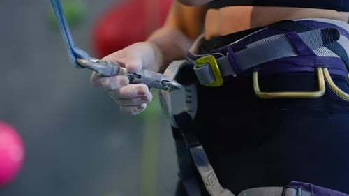 Alpinista coloca o cinto na cintura se preparando para o treinamento