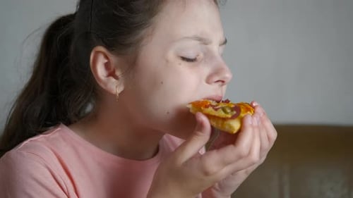 Girl Enjoying a Slice of Pizza Close Up