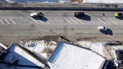 Luftbild von Fahrzeugen, die auf der Straße in einer verschneiten Stadt zirkulieren