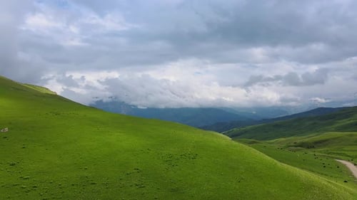Stunning Green Hills and a Cloudy Sky Create a Beautiful Scene for Nature Lovers