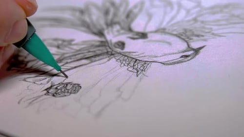 Person sketching with a green pencil on a white paper. Close up shot