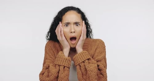 Shock, fear and emotion with a black woman in studio on a gray background looking worried or scared