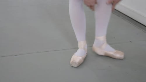 Female Ballet Dancer Putting on Ballet Shoes in Dance Studio 2529 Years