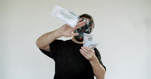 Man in Black Mask Throws Money in the Air