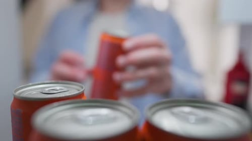 Une étagère, un propriétaire adolescent prend rapidement une canette de boisson en métal sur l'étagère du réfrigérateur d'une maison privée