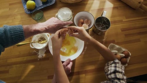 Child with Grandfather Preparing Dough while Baking Together at Kitchen Table