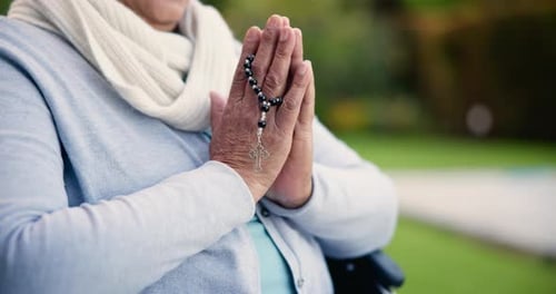 Hands, praying with cross and worship, trust and faith in God and patient in wheelchair