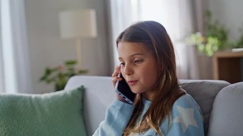 Smiling Girl Chatting on Mobile Phone Indoors