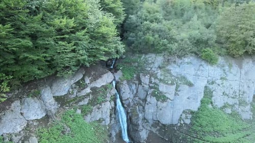 Picturesque Waterfall Flowing Through Lush Green Landscape