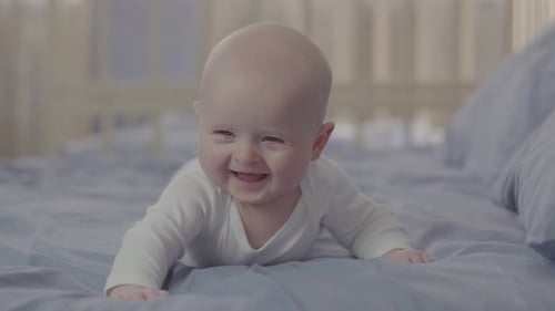 Happy Baby Smiling Lying on a Bed
