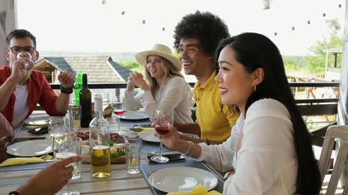 Friends Gathering for Meal Outdoors on Sunny Day
