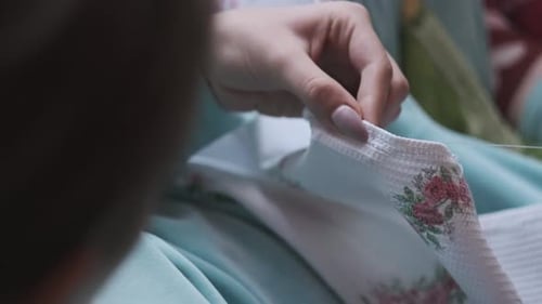 Woman Hands Sewing Intricate Floral Pattern on Fabric