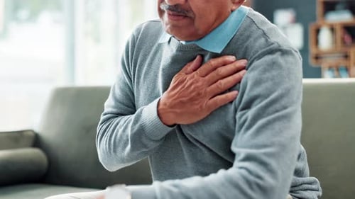 Elderly man, hand and chest pain or heart attack at home with healthcare risk or injury