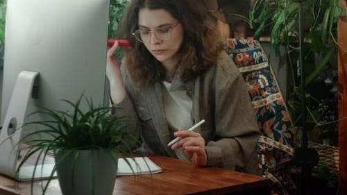 Businesswoman Listens to Voicemail on Her Smartphone in Office and Takes Notes