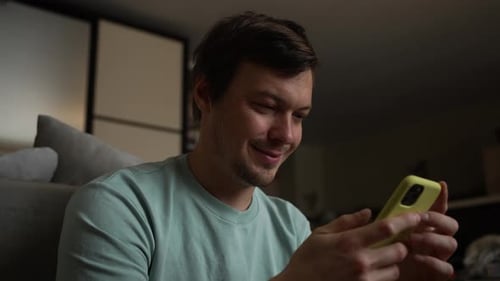 Happy Young Adult Using Smartphone Device Indoors