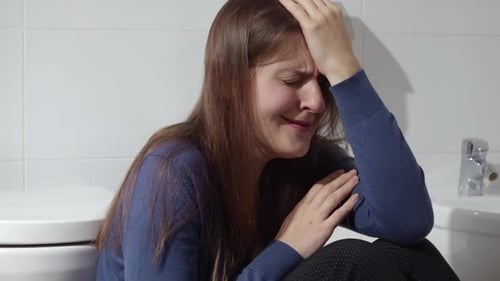 Distraught Woman Crying in a Bathroom