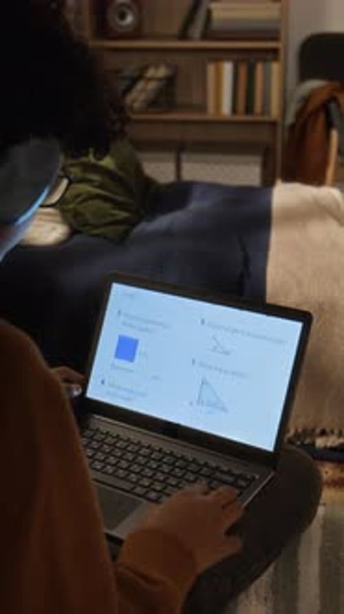 Student in Headphones Doing Geometry Test on Laptop during Remote Lesson
