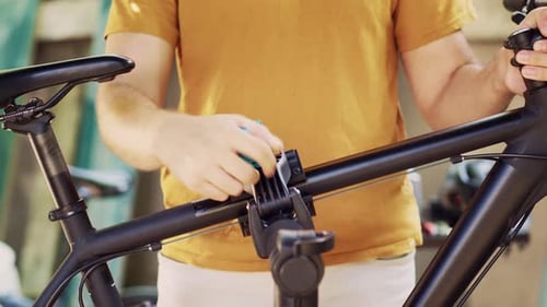 Man Clamps Bicycle Body on Repairstand