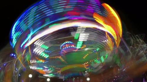 Spinning Amusement Park Ride with Blurred Lights at Night