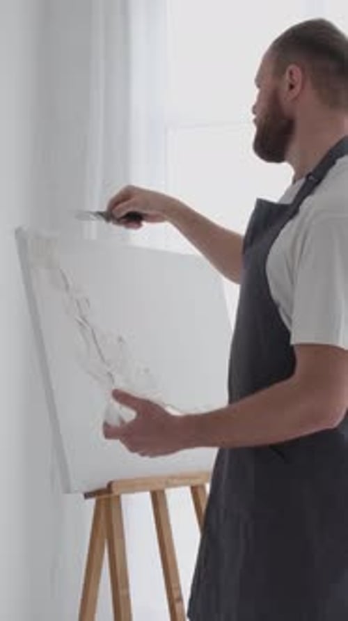 A Male Artist Works on Painting a Picture in a Creative Studio Creates an Abstract Painting Vertical