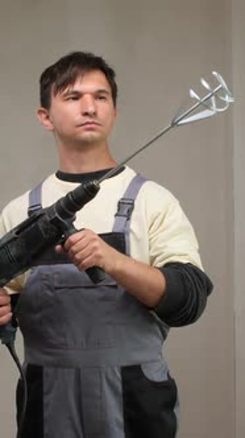 Man Holding Drill with Mixing Attachment