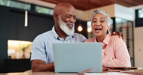 Happy Couple Laughing at Laptop in Modern Home