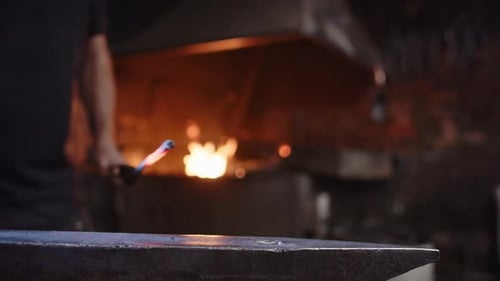 Blacksmith Hitting Hot Metal With Hammer on Anvil