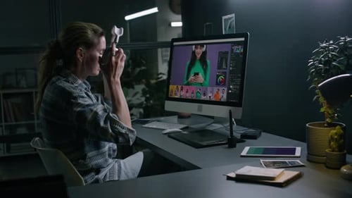 Woman Edits Photos on Computer in Office at Night