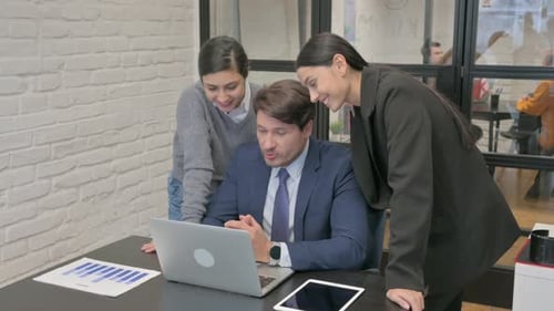 Colleagues Work Together at Computer in Modern Office