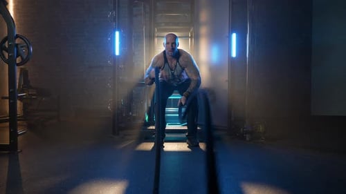 Man Exercising At The Gym With Battling Ropes. - front view