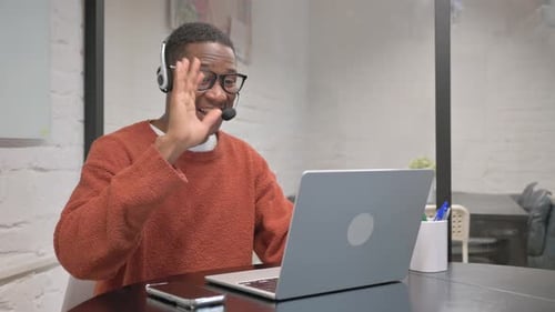 Man Video Conferencing on Laptop at Workplace