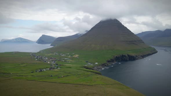 Clouds embracing the mountains of the Faroe Islands, aerial shot of a ...