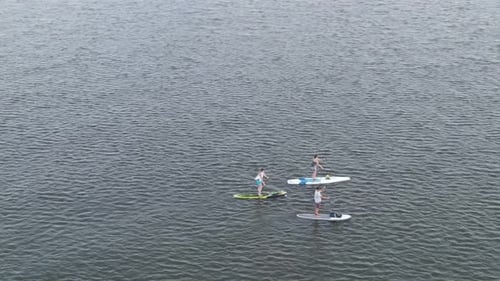Friends Having Fun By Standup Paddleboarding At Lake Pontchartrain In New Orleans. - aerial