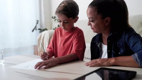 Madre e hijo haciendo los deberes para la escuela primaria en casa. Concepto educativo