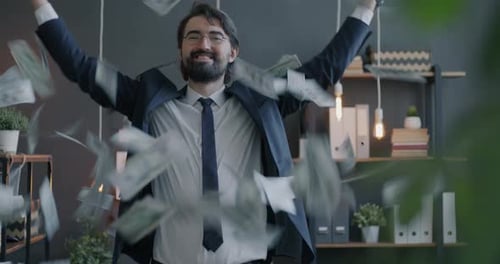 Loop of Happy Middle Eastern Entrepreneur Standing in Office While Money US Dollars Flying Around