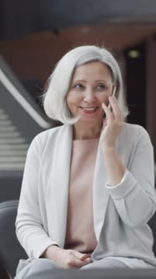 Businesswoman Talking on her Phone, Sitting in Modern Office