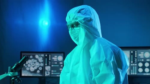 Scientist Works with Microscope in Lit Laboratory