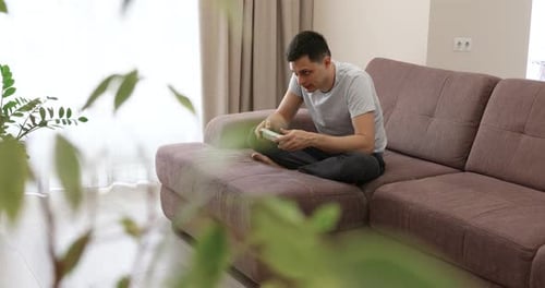 Man Playing Video Games on the Couch Indoors